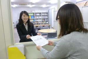 ＜写真２＞学内営業＜チラシ手渡し営業＞